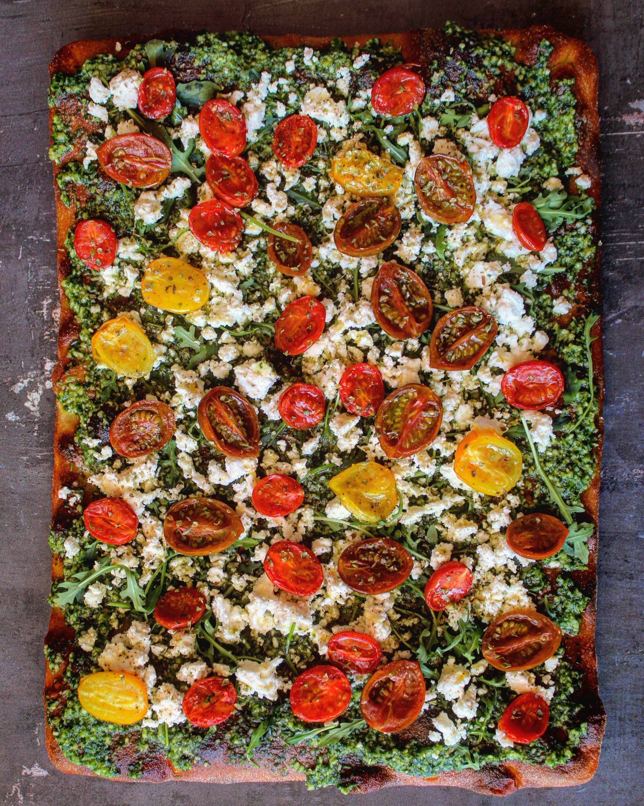 Focaccia con feta, pomodorini confit e pesto alla rucola