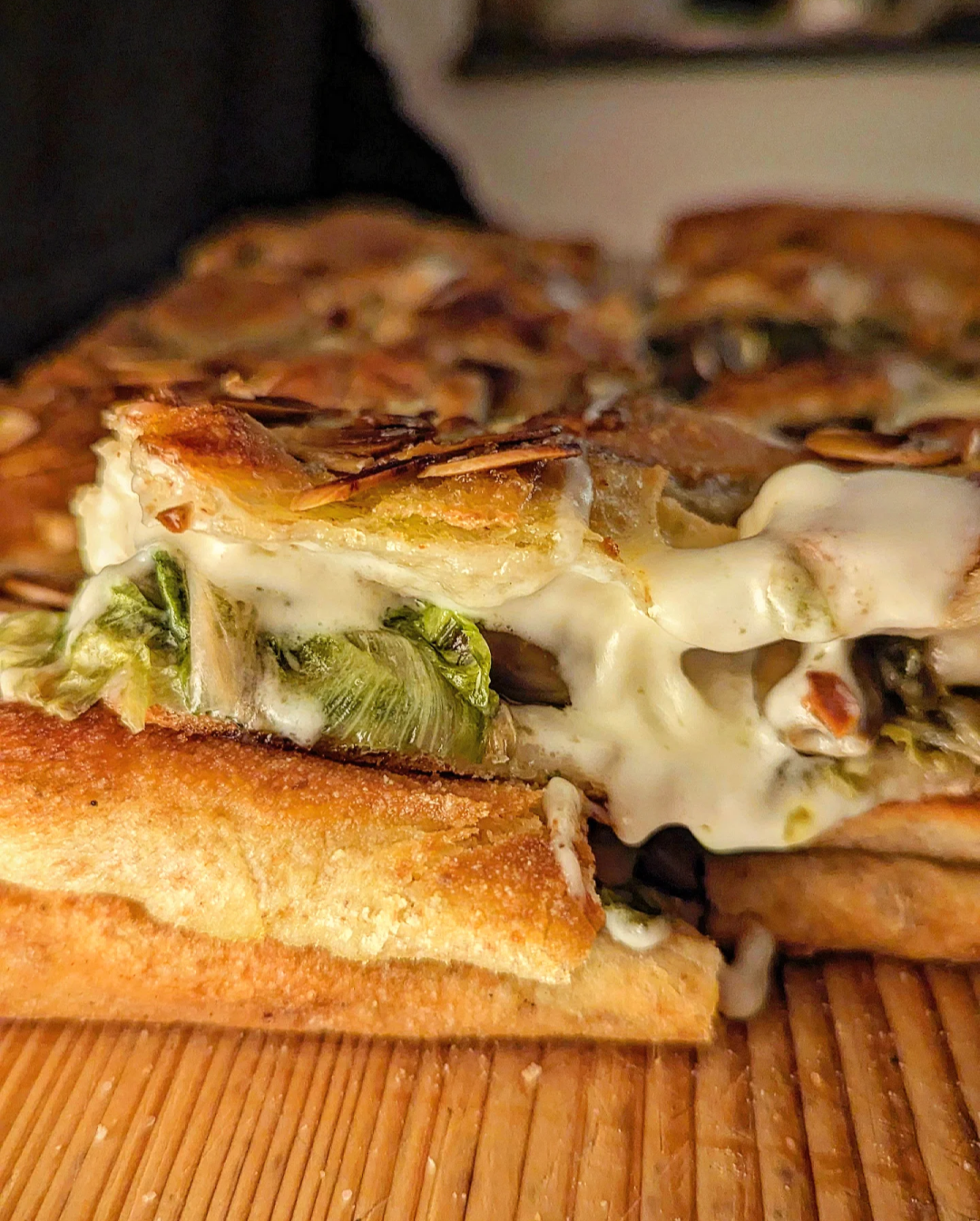 Focaccia baciata con scarola olive taggiasche taleggio e mandorle